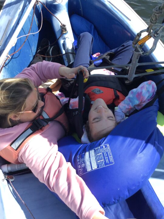 Photo of a girl with a neurodisability in a sailing boat with a Conductor
