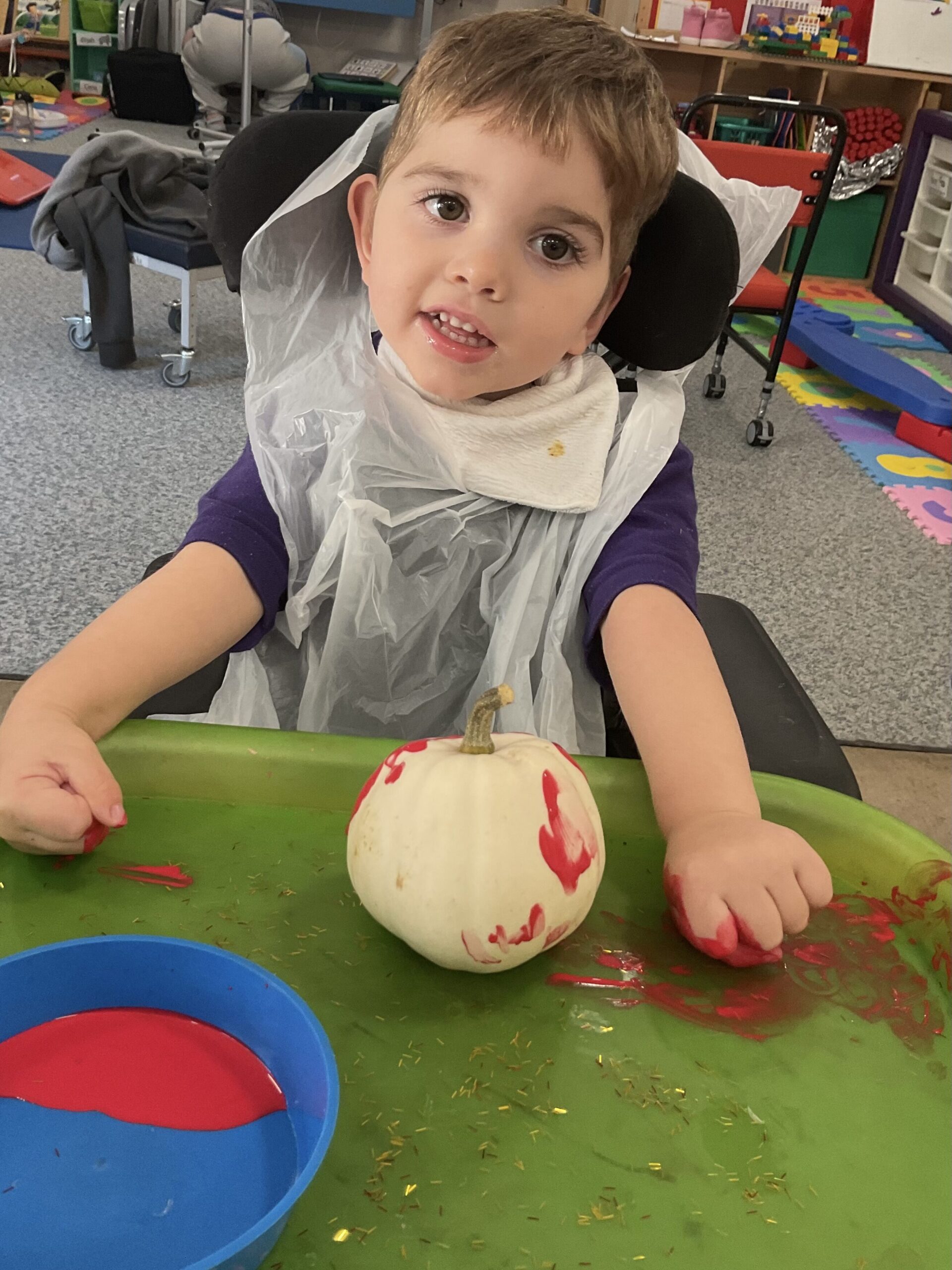 A pace student smiles to the camera with his painted pumpkin.