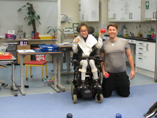 Child in wheelchair playing Boccia